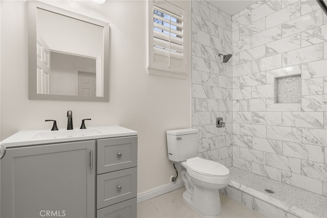 bathroom featuring vanity, toilet, tile patterned floors, and a tile shower