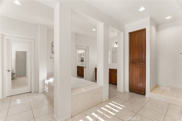 bathroom featuring vanity, tile patterned flooring, and tiled tub