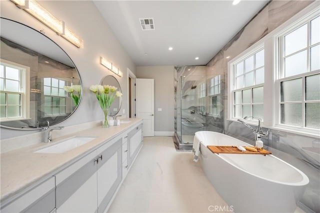 bathroom featuring plenty of natural light, shower with separate bathtub, and vanity