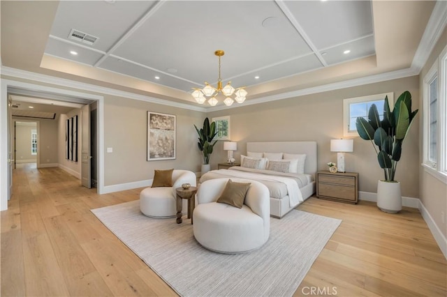 bedroom with an inviting chandelier, light hardwood / wood-style flooring, a tray ceiling, and crown molding