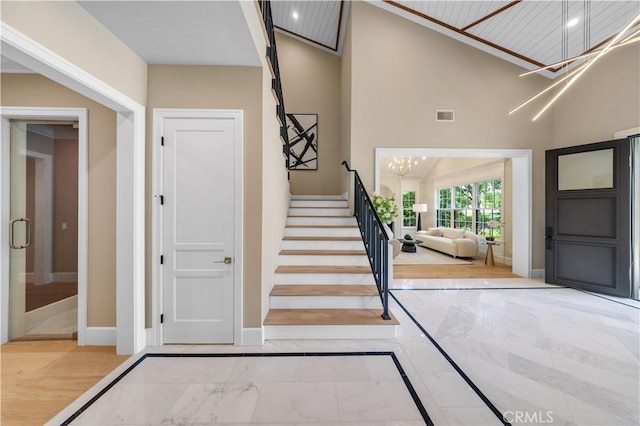 foyer with hardwood / wood-style floors, wooden ceiling, lofted ceiling, and a notable chandelier