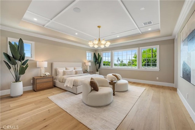 bedroom featuring a tray ceiling, crown molding, a notable chandelier, and light wood-type flooring