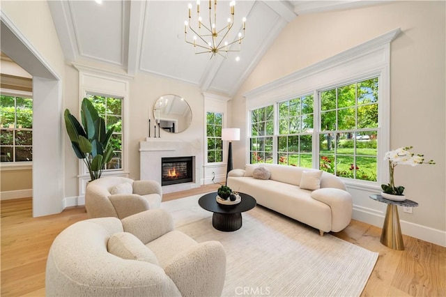 living room featuring a chandelier, beam ceiling, light hardwood / wood-style floors, and a healthy amount of sunlight