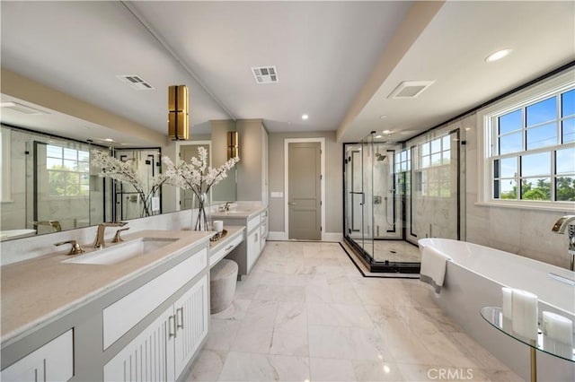 bathroom with vanity and shower with separate bathtub