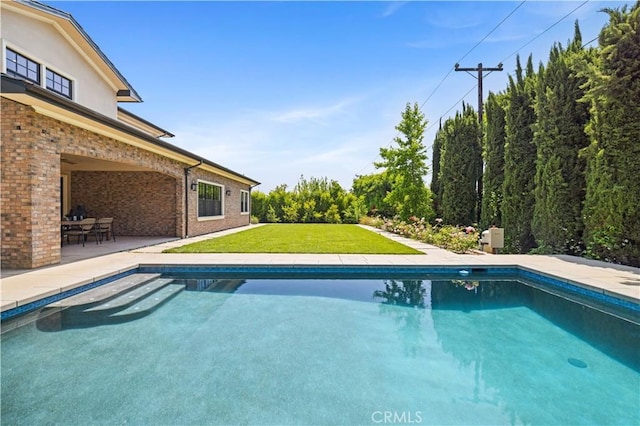 view of pool with a lawn and a patio area