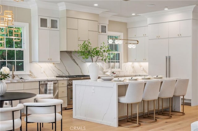 kitchen with high end stove, a wealth of natural light, sink, and a center island