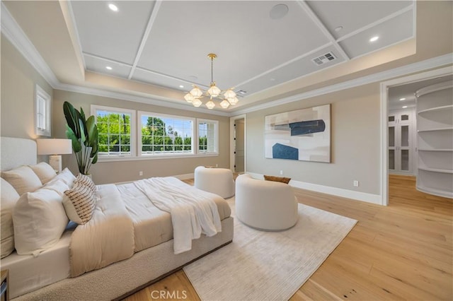 bedroom featuring a notable chandelier, light wood-type flooring, crown molding, and a tray ceiling