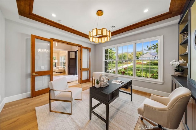 living room featuring a tray ceiling, french doors, a chandelier, and light wood-type flooring