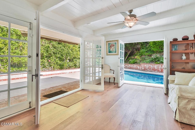 sunroom / solarium with beamed ceiling, a swimming pool, and ceiling fan