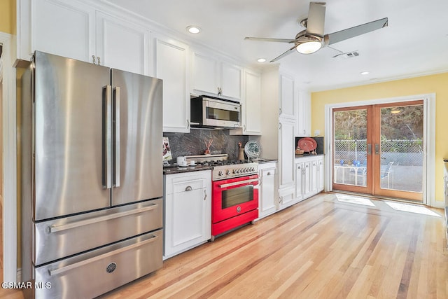 kitchen featuring white cabinets, backsplash, appliances with stainless steel finishes, and ceiling fan