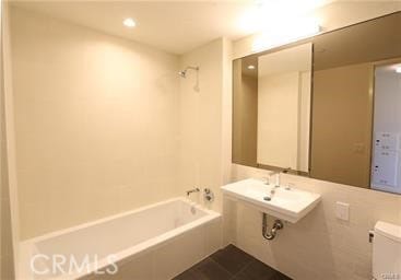 bathroom featuring tile patterned floors, shower / washtub combination, and toilet