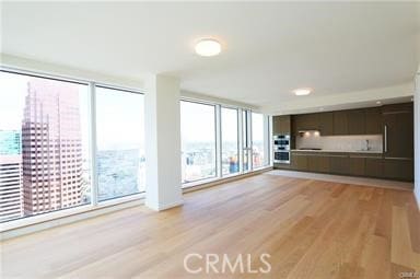 unfurnished living room with light hardwood / wood-style floors and expansive windows