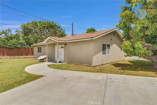 ranch-style home with a front yard and a patio area