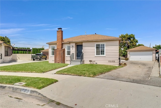 bungalow-style house with a garage, a front yard, and an outdoor structure