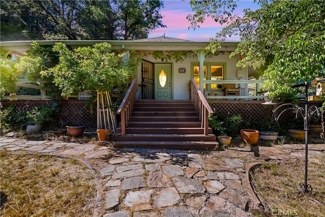 exterior entry at dusk featuring covered porch