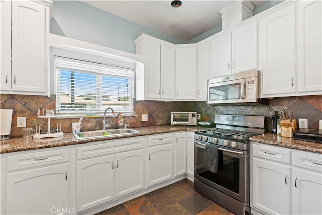 kitchen with stainless steel appliances, sink, decorative backsplash, and white cabinetry