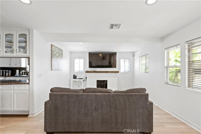 living room featuring bar area and light hardwood / wood-style flooring