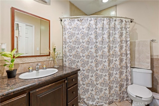 bathroom featuring curtained shower, tile patterned flooring, vanity, and toilet