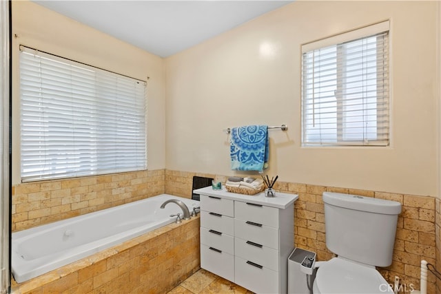 bathroom featuring a relaxing tiled tub and toilet