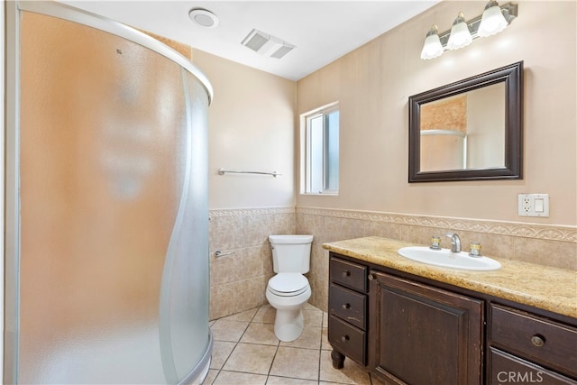 bathroom featuring tile walls, walk in shower, vanity, and toilet