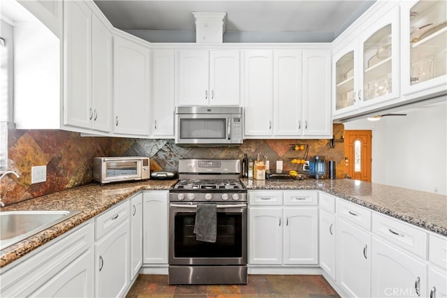 kitchen featuring stainless steel appliances, white cabinets, and tasteful backsplash