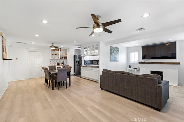 living room featuring ceiling fan and light hardwood / wood-style flooring