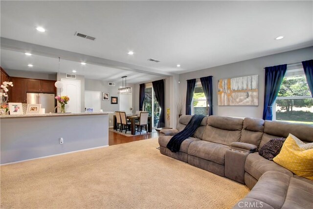 carpeted living room featuring plenty of natural light