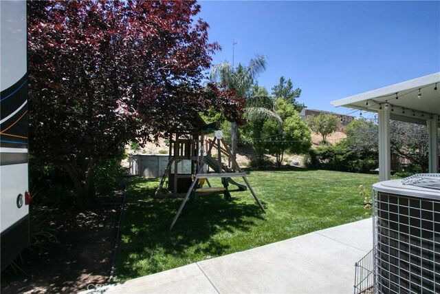 view of yard featuring a playground and central air condition unit