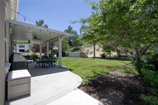 view of yard featuring ceiling fan and a patio area