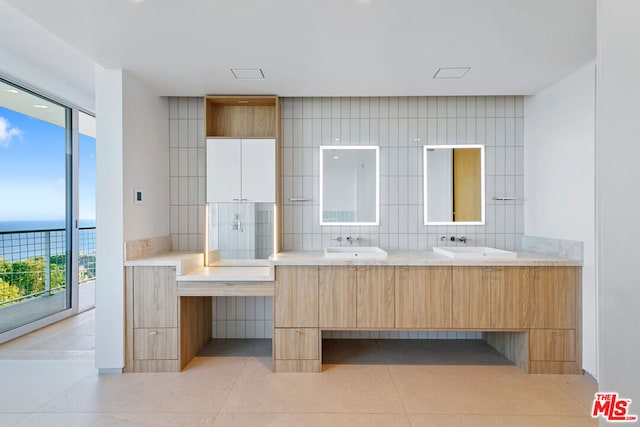 bathroom featuring vanity, a water view, and tasteful backsplash