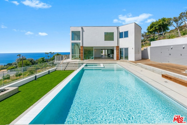 view of pool featuring a water view, a yard, and a patio