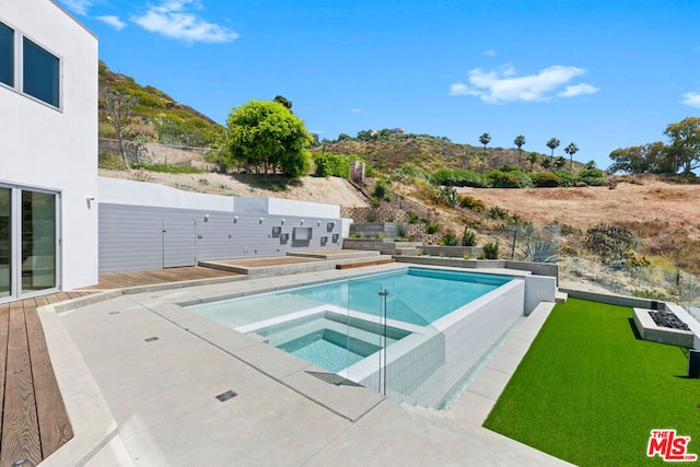 view of swimming pool with a mountain view and an in ground hot tub