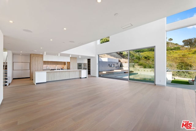 unfurnished living room with a healthy amount of sunlight and light hardwood / wood-style flooring