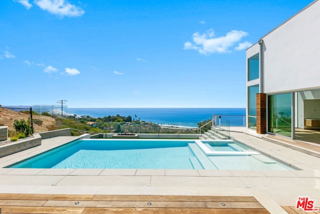 view of swimming pool featuring an in ground hot tub and a water view