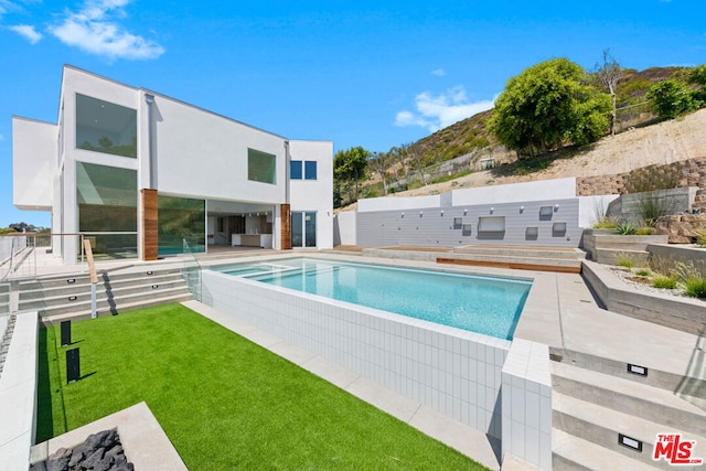 view of pool featuring a yard and a patio