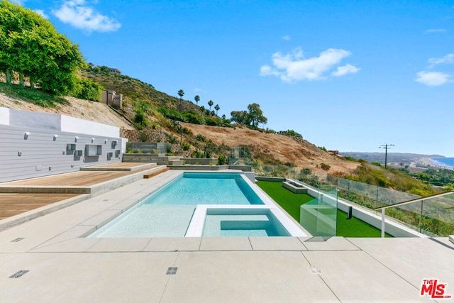 view of pool featuring a mountain view, an in ground hot tub, and a patio area