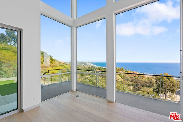 unfurnished sunroom with a water view