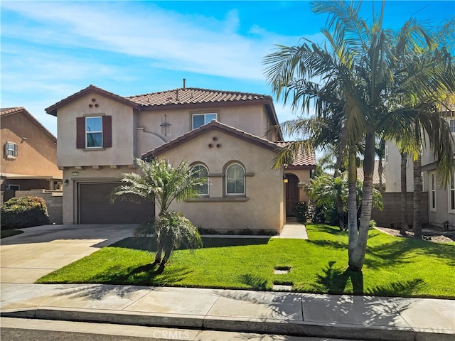 mediterranean / spanish home with a front yard and a garage