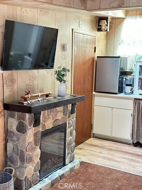 interior space featuring a fireplace, wood-type flooring, and wooden walls