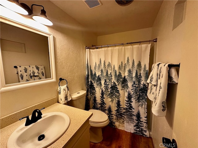 bathroom with wood-type flooring, a shower with shower curtain, vanity, and toilet