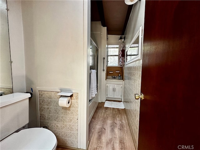 bathroom featuring hardwood / wood-style floors, sink, tile walls, and toilet