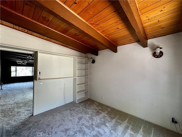 empty room featuring beam ceiling, carpet flooring, and wooden ceiling