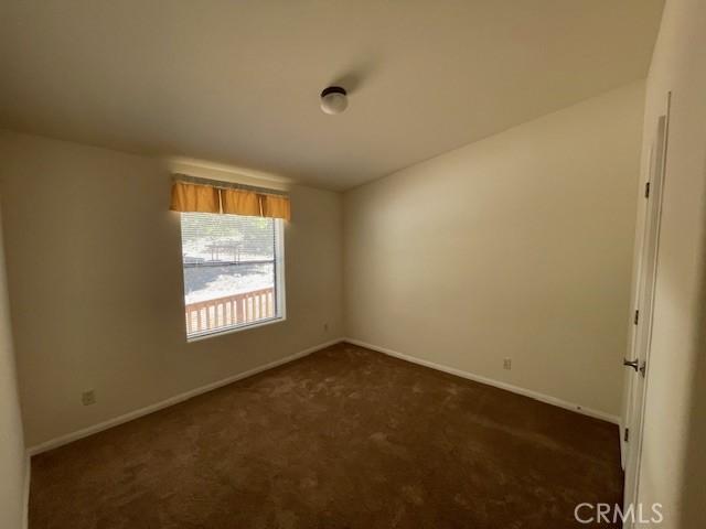 41501 Island Dr, Forest Falls, CA 92339 - spare room featuring dark carpet, lofted ceiling, and baseboards