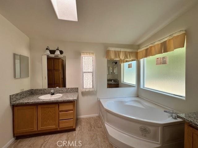 41501 Island Dr, Forest Falls, CA 92339 - bathroom with plenty of natural light, vanity, a garden tub, and baseboards