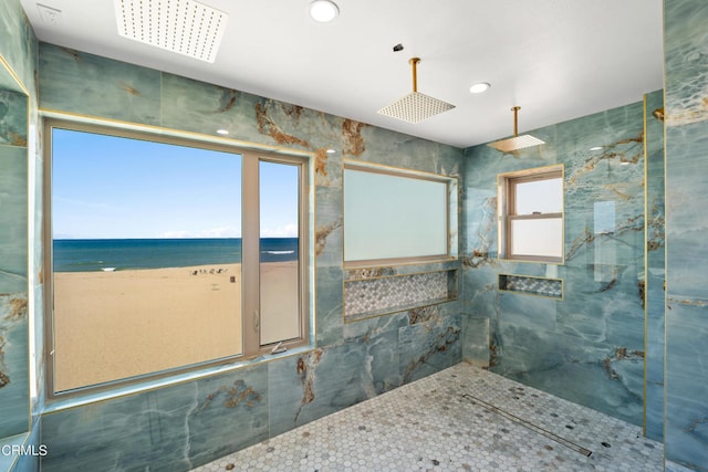 bathroom featuring tile walls, a water view, and a healthy amount of sunlight