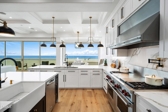 kitchen with appliances with stainless steel finishes, a water view, white cabinetry, pendant lighting, and sink