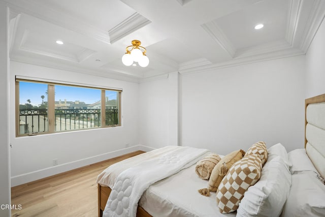 bedroom with coffered ceiling, ornamental molding, light hardwood / wood-style floors, and a water view