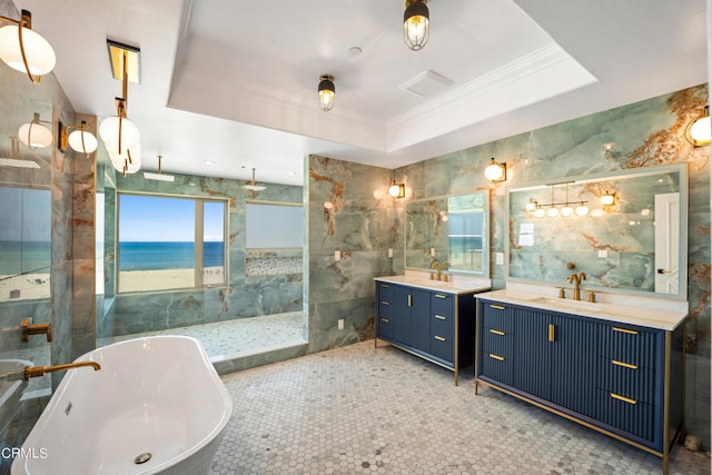 bathroom featuring a water view, a raised ceiling, vanity, independent shower and bath, and ornamental molding