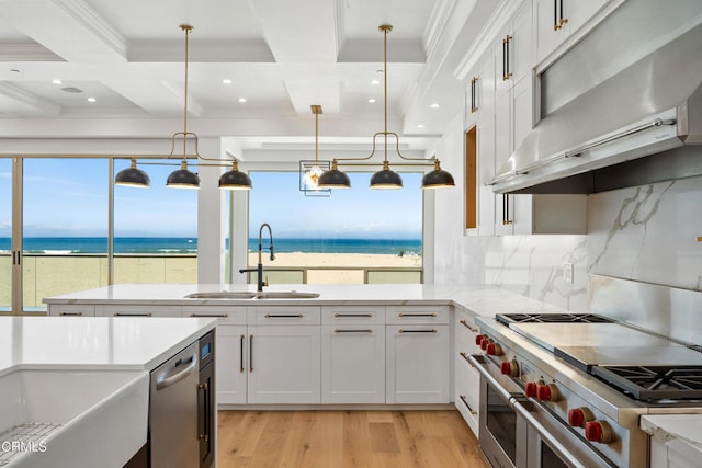 kitchen with pendant lighting, a water view, white cabinetry, and double oven range