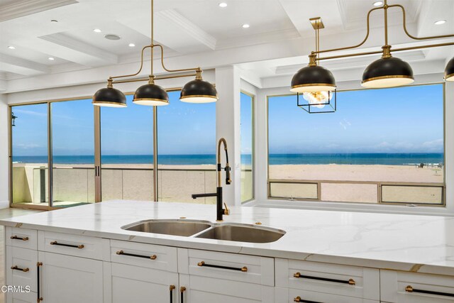 kitchen featuring a water view, a beach view, and decorative light fixtures